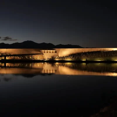 Bodega Zuccardi Valle de Uco iluminada de noche reflejada en un estanque de agua
