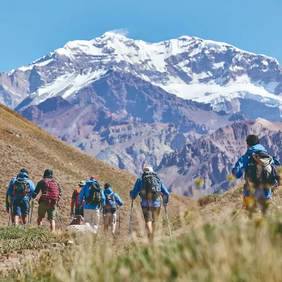 Group of hikers walking toward the Andes with Aconcagua in the background.