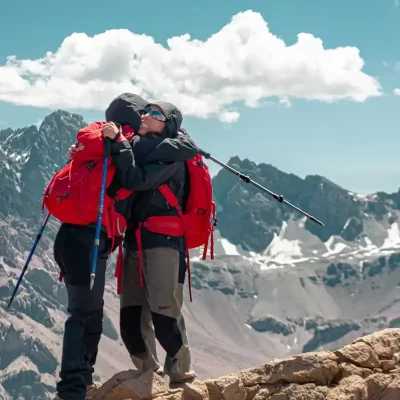 Two trekkers embracing at high altitude during the Trekking – 7 Days Aconcagua Park – Plaza Francia + Plaza de Mulas + Bonete 5000m tour.