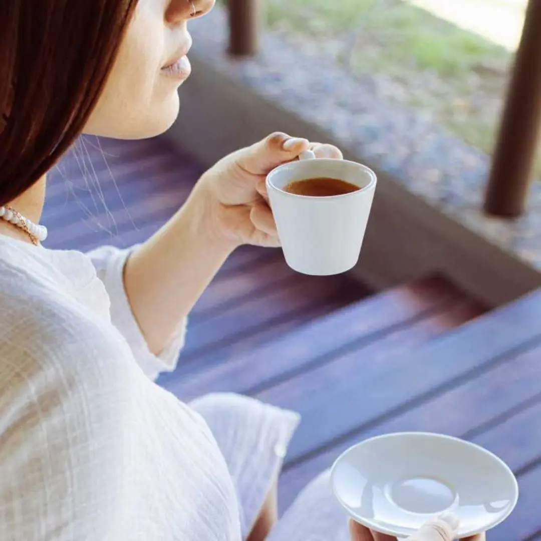 Woman relaxing with a cup of herbal tea at a spa retreat