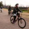 Woman riding a bicycle on a vineyard road in Mendoza wine country.