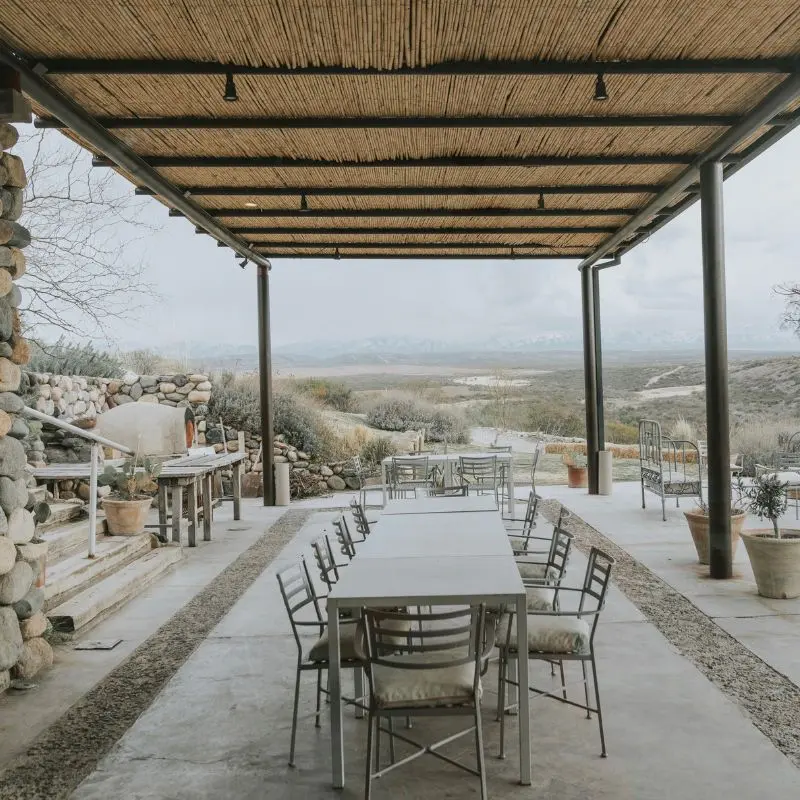 Cozy winery lunch setting with snow-covered Andes in the background.