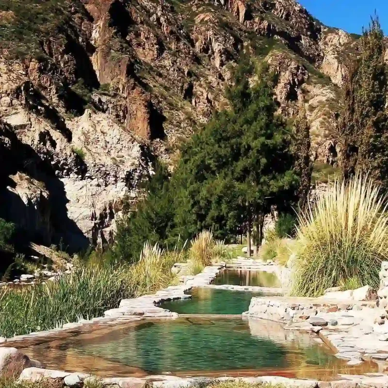 Natural thermal pools surrounded by mountains at Cacheuta Thermal Park.