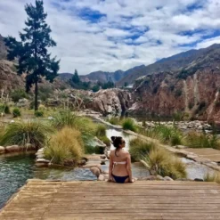 Visitante relajándose junto a aguas termales naturales en el Parque Termal de Cacheuta.