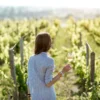 Woman enjoying a glass of white wine among the vineyards at Bodega La Mansa, San Rafael.