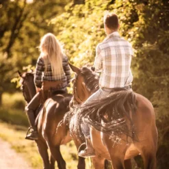 Couple enjoying a shared horseback riding tour in Mendoza Andes with local gauchos and mountain landscapes