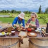 Guests making traditional Argentine empanadas outdoors at a winery in Mendoza.