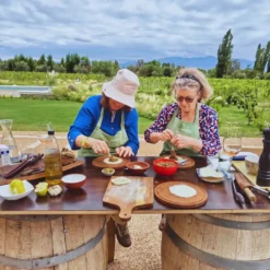 Guests making traditional Argentine empanadas outdoors at a winery in Mendoza.
